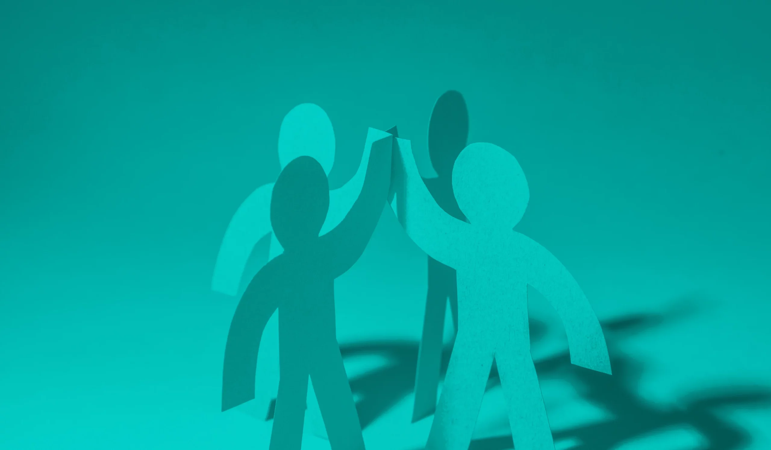 illustrative photo of four cut out human shapes with arms intersecting meant to abstractly illustrate partnership between an agency and a company