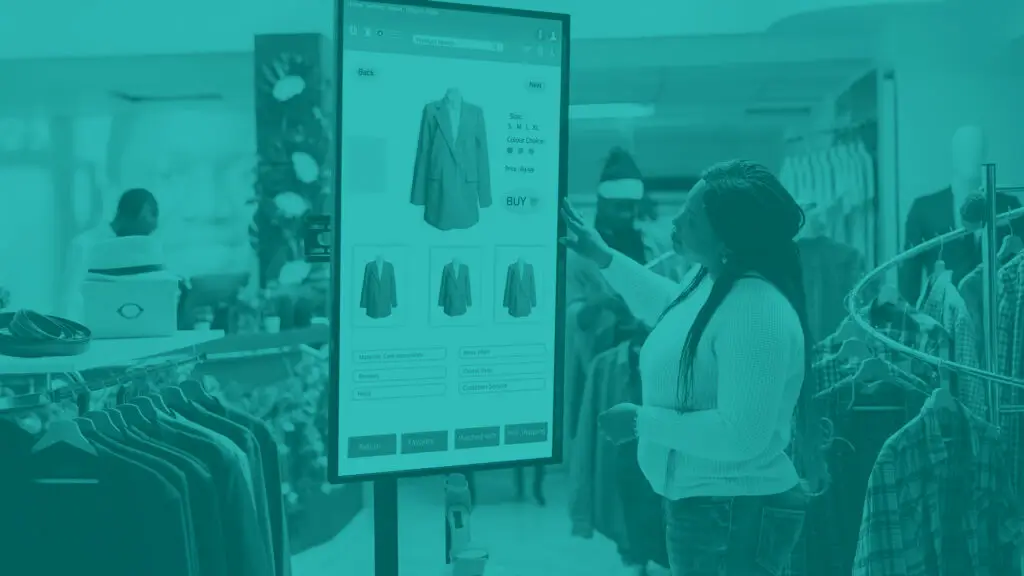 Shopper in retail store selecting items to buy from self service checkout kiosk, reviewing modern clothes and sizes on interactive monitor. Young woman looking at products on board