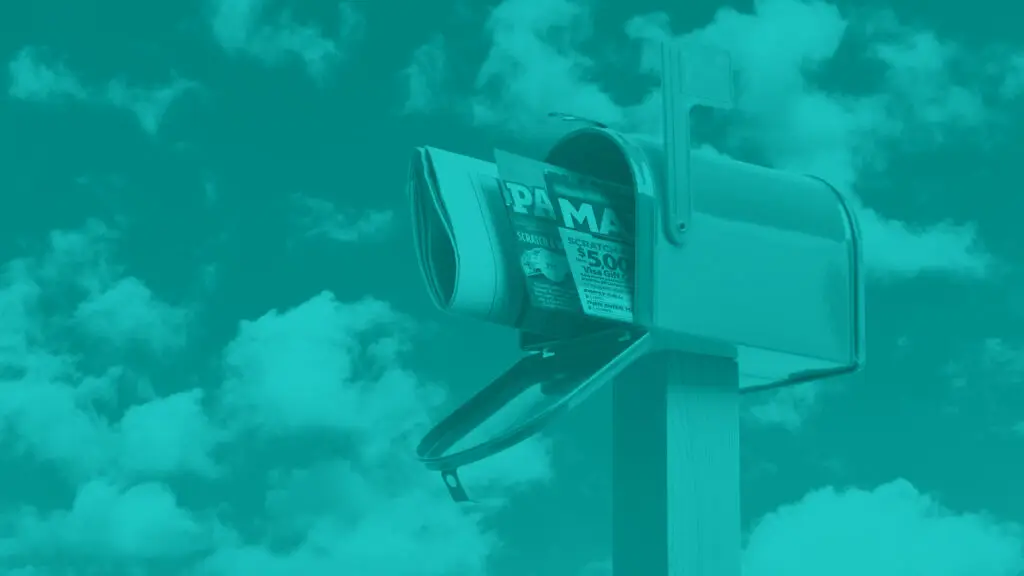 Open mailbox on wooden post with direct mail sticking out of the front. sky with clouds in the background.